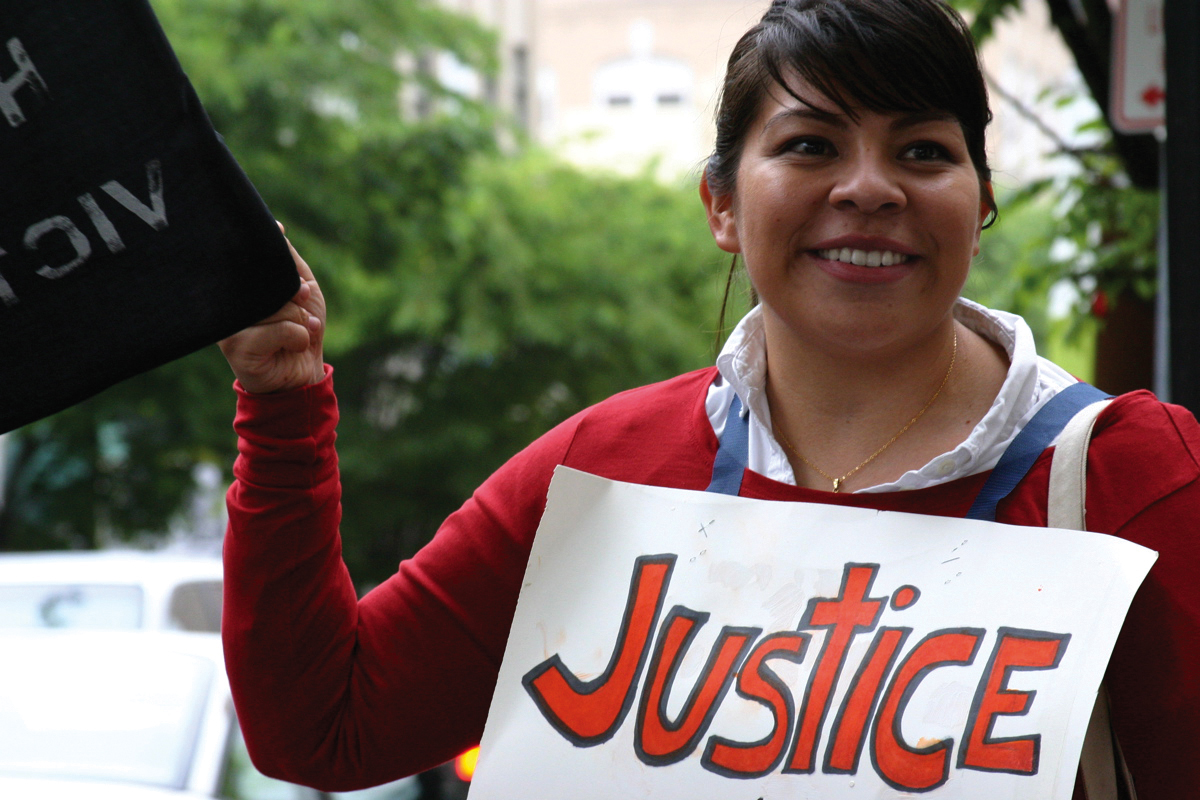 A young woman holding a sign that says justice A young woman holding a sign that says justice