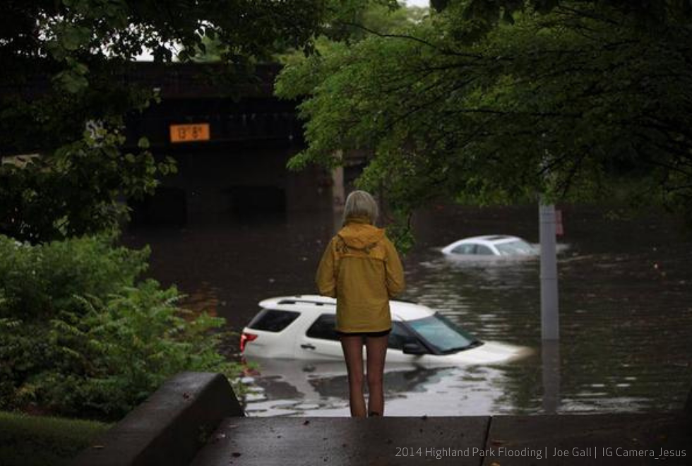 Woman looking out over flooded street. 2014 Highland Park. Credit: Joe Gall / Camera Jesus