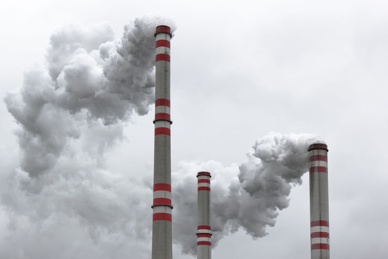 Three power plant smoke stacks. Photo credit: martin33 / Shutterstock