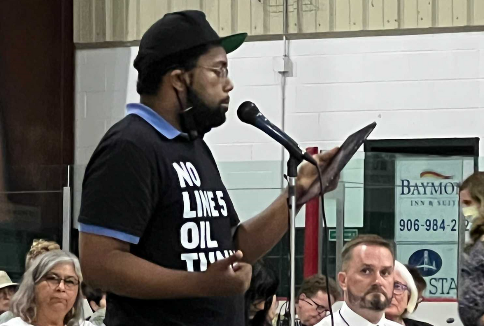 Erik McCleary testifying at USACE hearing wearing No Line 5 Oil Tunnel shirt.