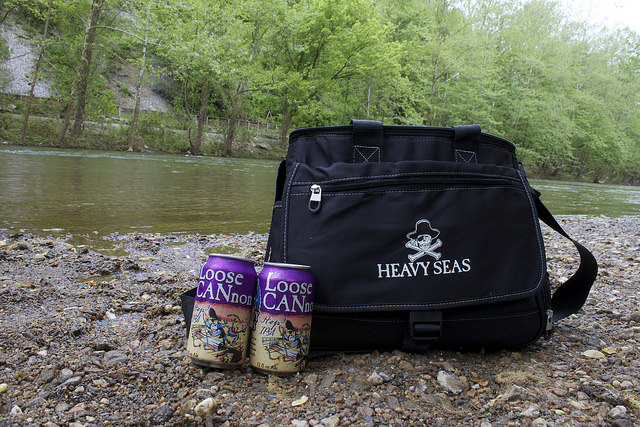 Tap Into Clean Water with Heavy Seas Beer Heavy Seas Beer Shoulder Bag an Two Cans of Beer By River. Photo credit: Heavy Seas Beer