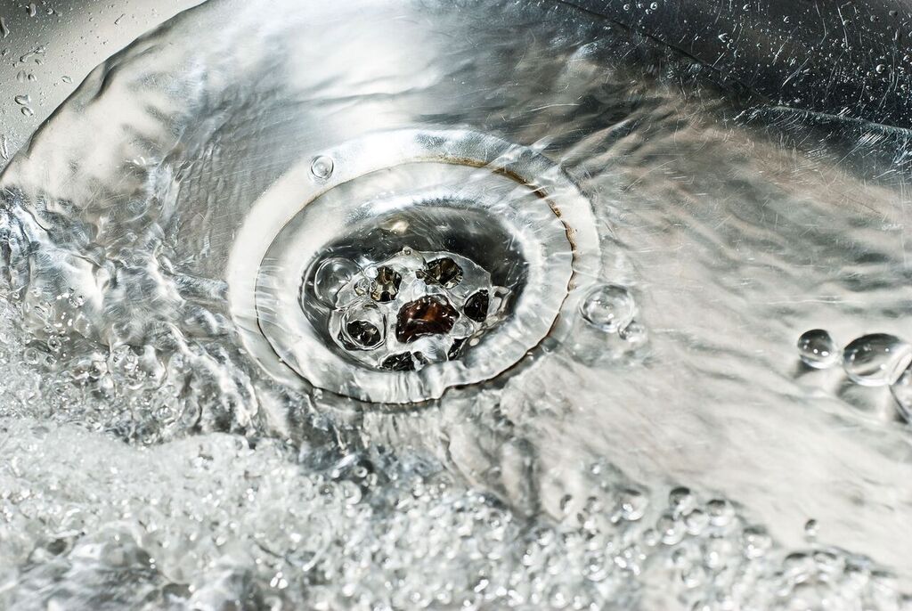 Water flowing into a drain. Photo credit: Jitinatt Jufask / Shutterstock