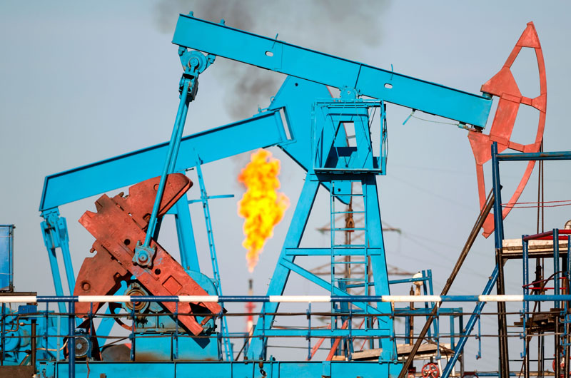 Pumpjacks with a methane flare in the background. Photo credit: Leonid Ikan / Shutterstock