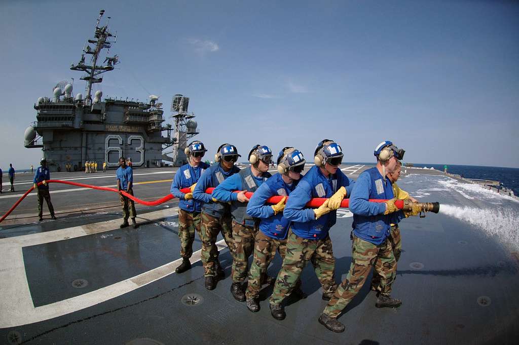 air department personnel wash aqueous film forming foam AFF off a plane